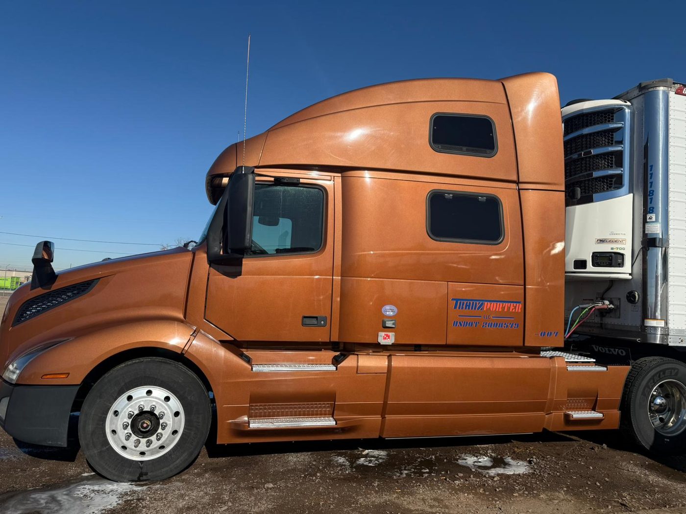 Tranzporter LLC Volvo cab with USDOT 2008579 on the door, coupled to a refrigerated trailer